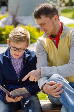 Genç adam genç bir kitap okumak için yardım