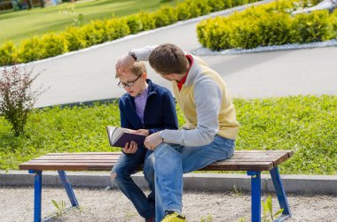 Genç adam genç bir kitap okumak için yardım