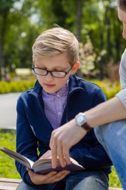 Genç adam genç bir kitap okumak için yardım