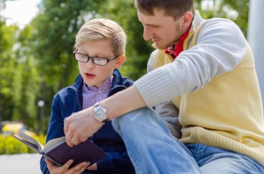 Genç adam genç bir kitap okumak için yardım