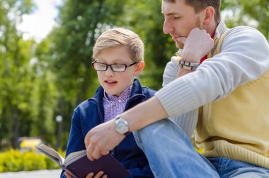 Genç adam genç bir kitap okumak için yardım
