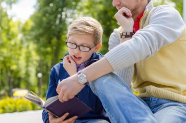 Genç adam genç bir kitap okumak için yardım