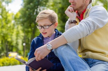 Genç adam genç bir kitap okumak için yardım