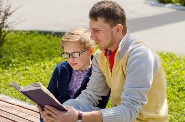 Genç adam genç bir kitap okumak için yardım