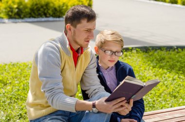 Genç adam genç bir kitap okumak için yardım