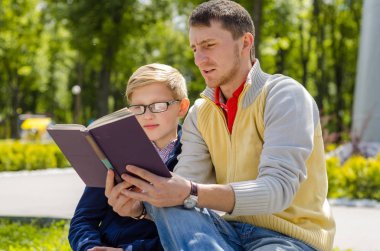 Genç adam genç bir kitap okumak için yardım