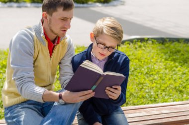 Genç adam genç bir kitap okumak için yardım