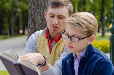 Genç adam genç bir kitap okumak için yardım