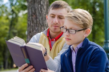 Genç adam genç bir kitap okumak için yardım