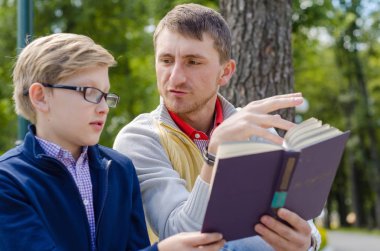 Genç adam genç bir kitap okumak için yardım