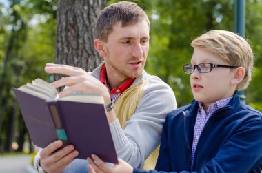 Genç adam genç bir kitap okumak için yardım