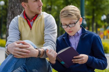 Genç adam genç bir kitap okumak için yardım