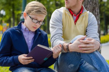 Genç adam genç bir kitap okumak için yardım