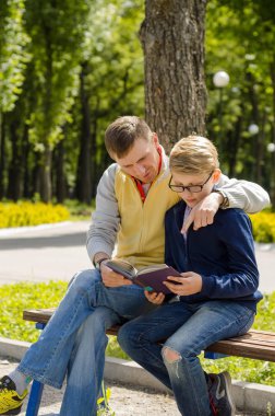 Genç adam genç bir kitap okumak için yardım