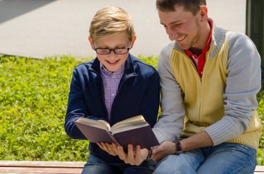 Genç adam genç bir kitap okumak için yardım