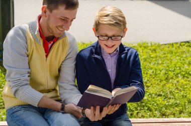 Genç adam genç bir kitap okumak için yardım