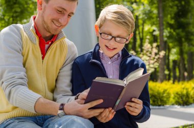 Genç adam genç bir kitap okumak için yardım