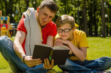 Genç adam genç kızla bir kitap okuyor