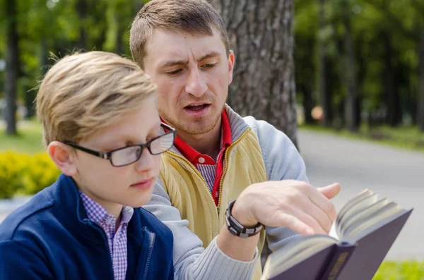 Młody człowiek jest pomoc nastolatek czytać książki — Zdjęcie stockowe