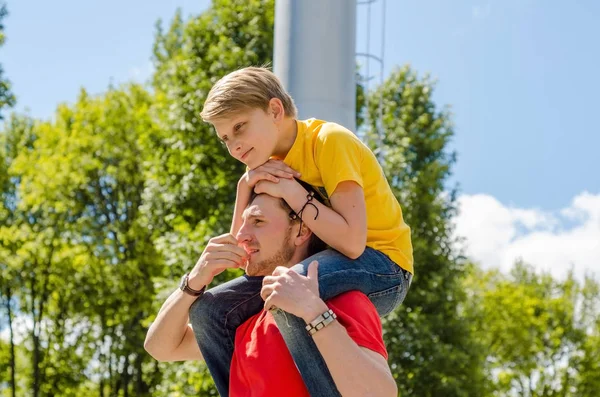 Teenages sedí na mladý mans krk — Stock fotografie