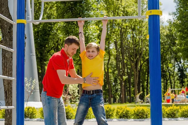 Young man is helping teenager on the breams — Stock Photo, Image