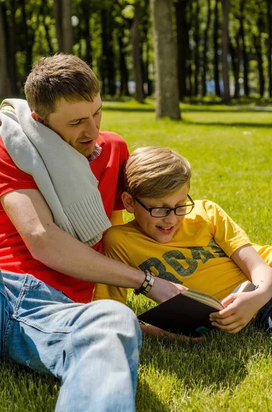 Mladý muž je čtení knih s teenager — Stock fotografie