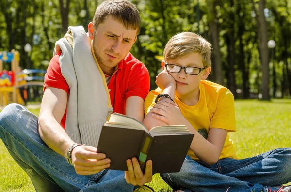 Młody człowiek jest czytanie książek z nastolatkiem — Zdjęcie stockowe