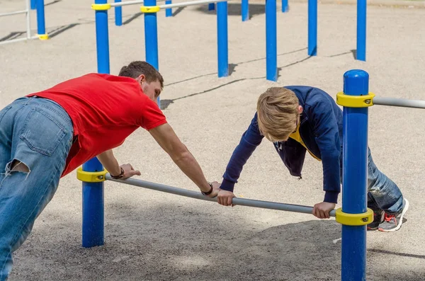Man is making push ups with teenager — Stock Photo, Image