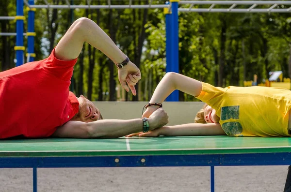 Den unge mannen leker med tenåringen i parken. – stockfoto