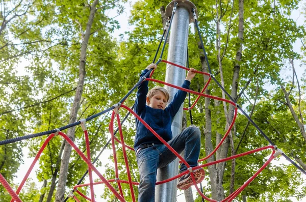 Adolescente está jugando en el parque de cuerdas — Foto de Stock