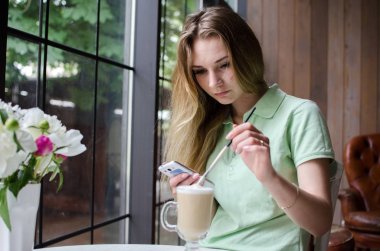 kafede cep telefonunu kullanan kadın