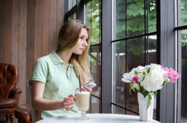 kafede cep telefonunu kullanan kadın