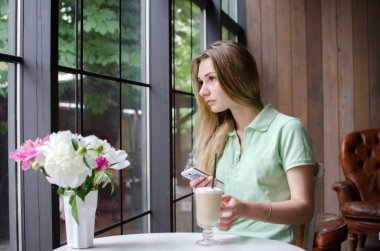 kafede cep telefonunu kullanan kadın