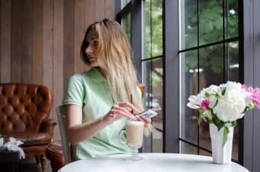 kafede cep telefonunu kullanan kadın