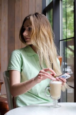 kafede cep telefonunu kullanan kadın
