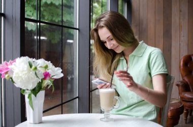 kafede cep telefonunu kullanan kadın