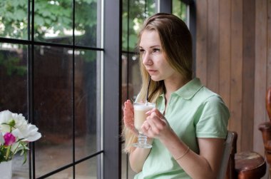 Kadın kafede kahve içiyor.