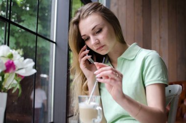 kadın cafede cep telefonunu kullanıyor