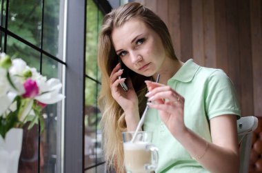 kadın cafede cep telefonunu kullanıyor