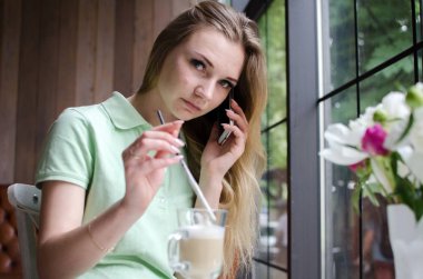 kadın cafede cep telefonunu kullanıyor