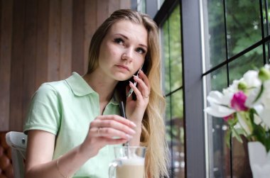 kadın cafede cep telefonunu kullanıyor
