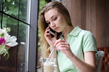 kadın cafede cep telefonunu kullanıyor