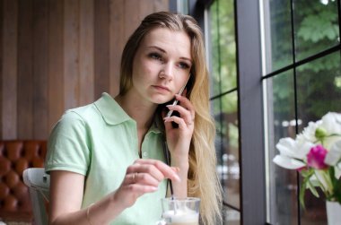 kadın cafede cep telefonunu kullanıyor