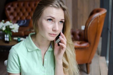 kadın cafede cep telefonunu kullanıyor