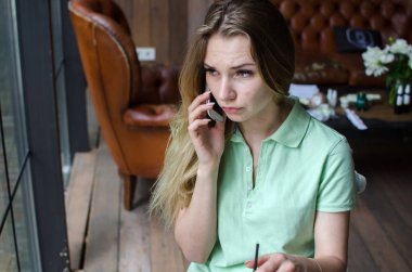 kadın cafede cep telefonunu kullanıyor