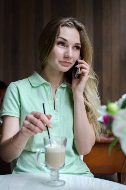 kadın cafede cep telefonunu kullanıyor