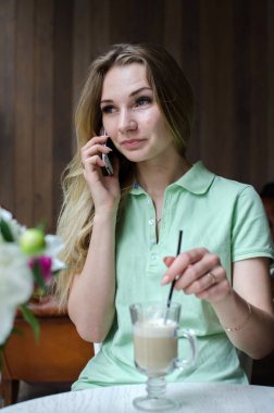 kadın cafede cep telefonunu kullanıyor