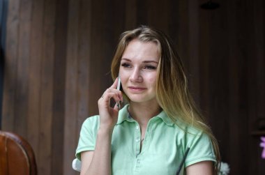 kadın cafede cep telefonunu kullanıyor