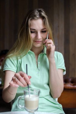 kadın cafede cep telefonunu kullanıyor