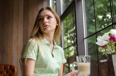 Kadın kafede kahve içiyor.